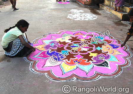 Little Girl Giving Colors to Freehand Rangoli
